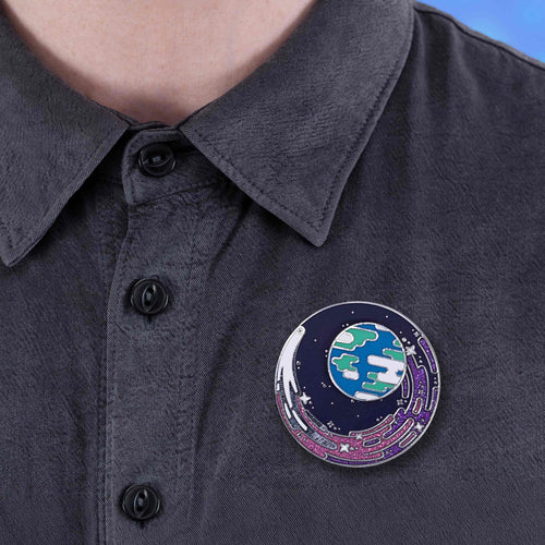 Limited Edition Pin with cosmic design on a dark shirt against a blue background